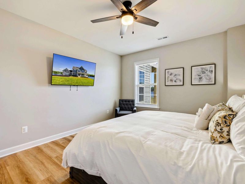 Comfortable bedroom with a king-size bed, ceiling fan, and wall-mounted TV