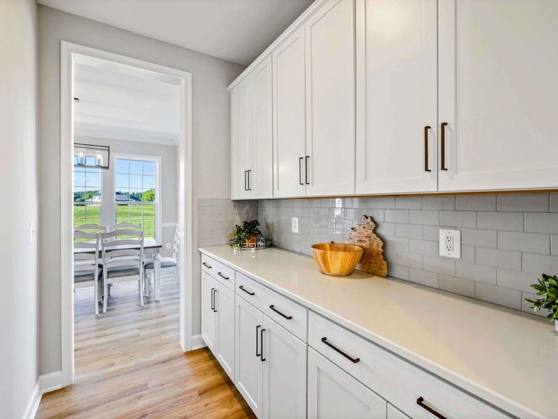Bright and airy hallway with extensive counter space and storage, leading to a scenic dining area