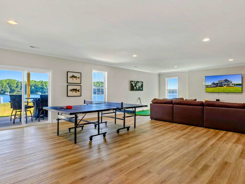 Enjoy spacious indoor entertainment with a ping pong table, cozy seating area, and stunning lake views