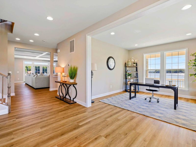 Spacious entryway leading to a modern home office with ample natural light and serene lake views