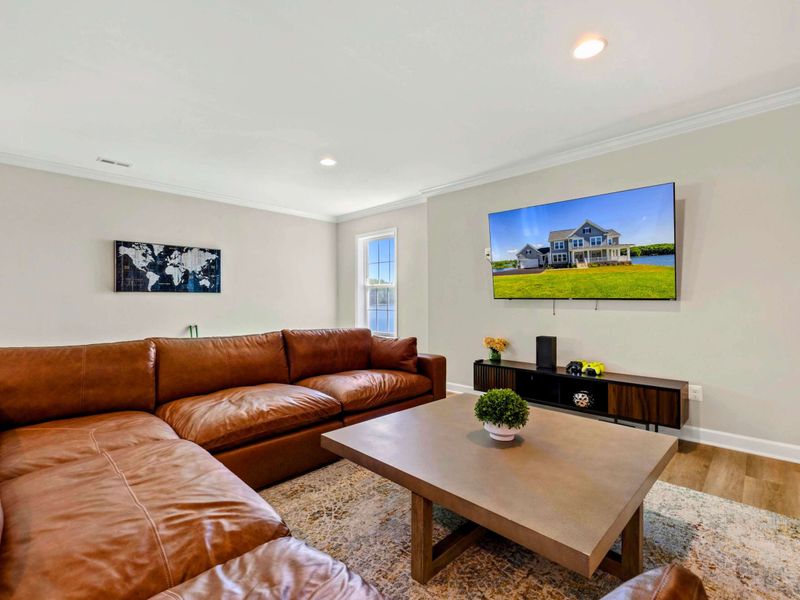Spacious living area with a large sectional sofa and a mounted flat-screen TV for your entertainment.