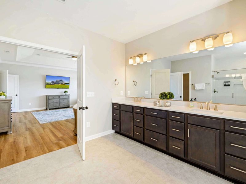Spacious en-suite bathroom with a double vanity and ample storage, leading to a luxurious Primary Bedroom