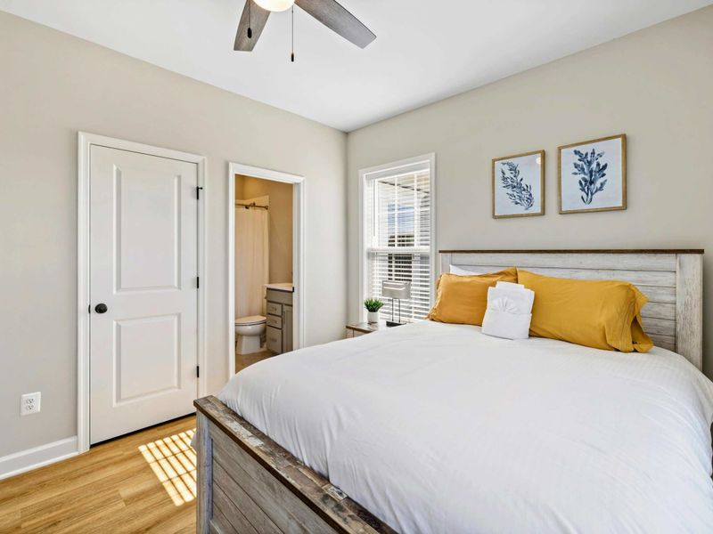 Cozy bedroom with a queen-size bed, ceiling fan, and en-suite bathroom