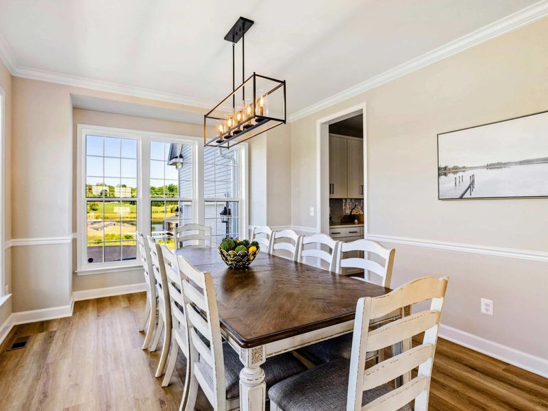 Charming dining room with stylish lighting, large windows, and access to an outdoor view