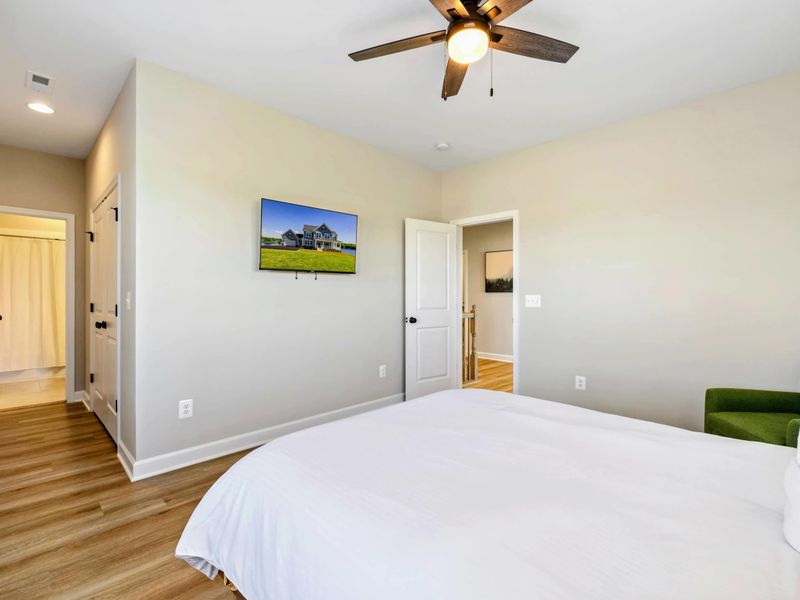 Cozy bedroom with a queen-size bed, wall-mounted TV, and en-suite bathroom access