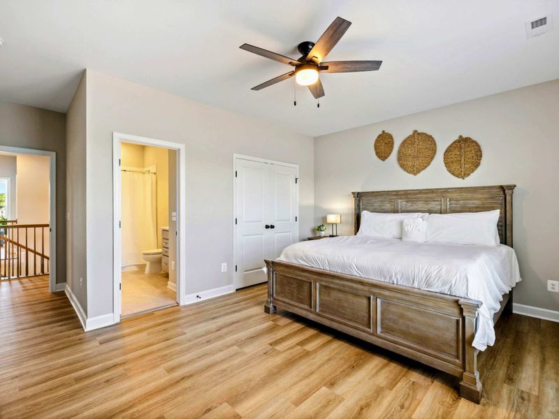 Spacious bedroom with a king-size bed, ceiling fan, and en-suite bathroom access