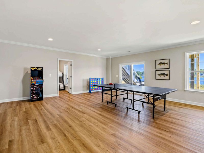 Our spacious game room features a ping pong table, arcade machine, and stunning lake views, perfect for fun and relaxation.