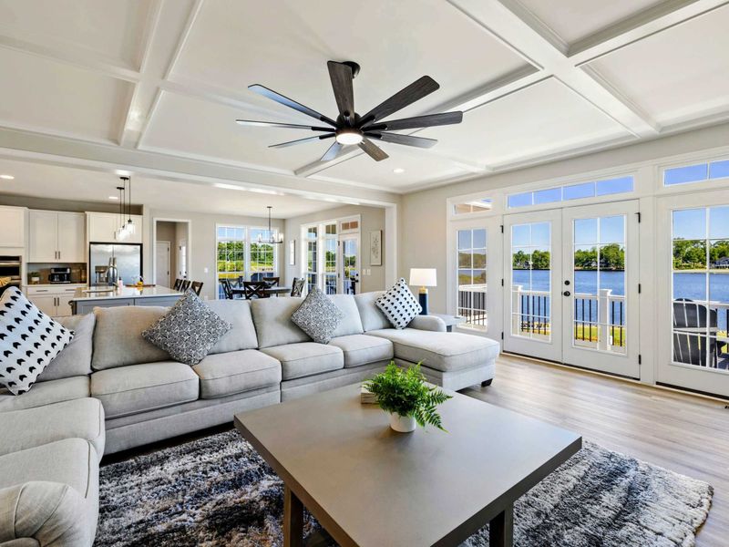 Our open-concept living area features a spacious sectional, modern decor, and breathtaking lake views through expansive windows and French doors.