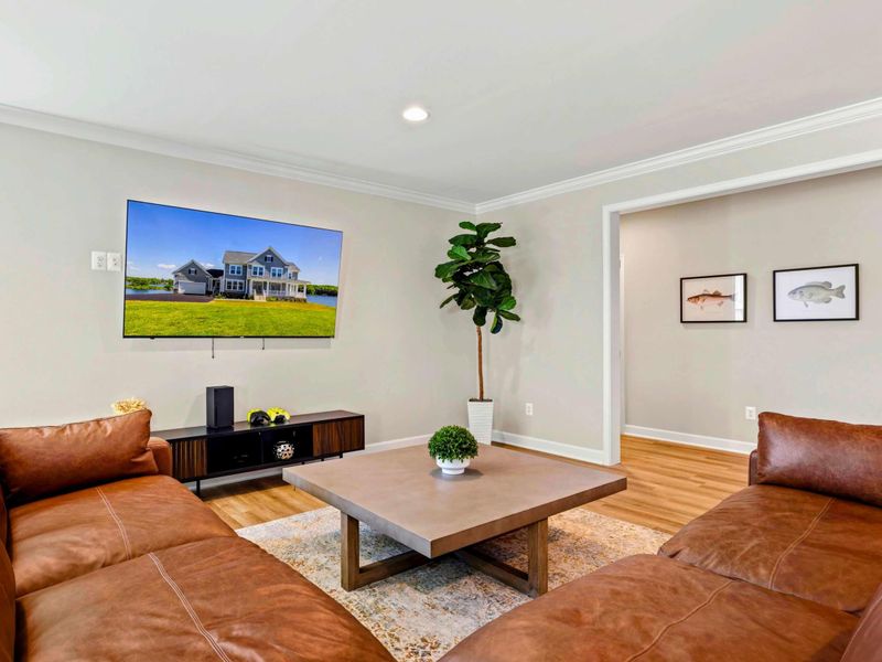 Spacious living area with a large sectional sofa and a mounted flat-screen TV for your entertainment.