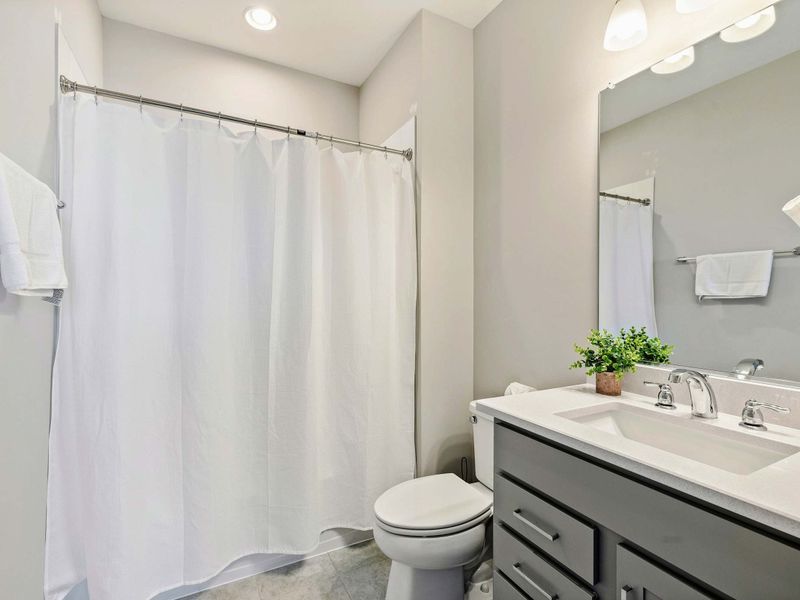 Modern bathroom with a shower-tub combination, vanity, and fresh decor