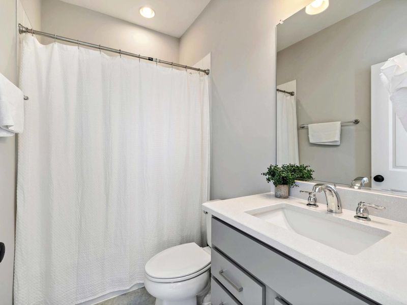 Modern bathroom with a shower-tub combination, vanity, and elegant decor