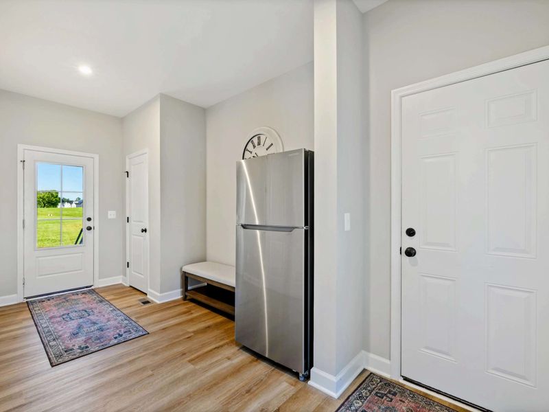 Bright entryway with additional refrigerator and easy access to outdoor spaces