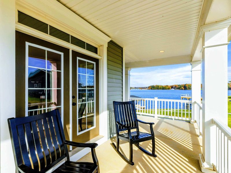 A charming porch with rocking chairs and a stunning view of the lake, perfect for relaxing and enjoying the scenery