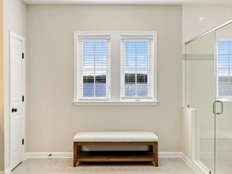 Bright bathroom with a bench and stunning lake views through the window
