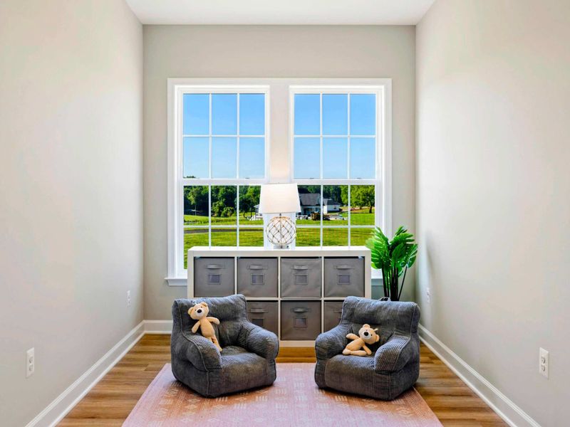 Cozy nook with child-sized seating, plush toys, and a scenic view from large windows