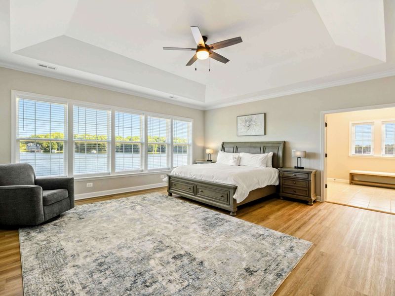 Spacious Primary Bedroom with a king-size bed, large windows, and an en-suite bathroom