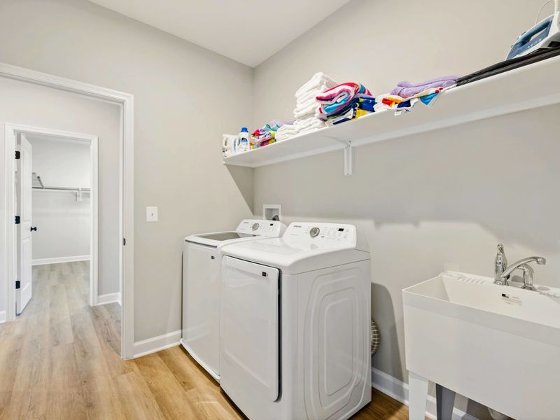 Convenient laundry room equipped with washer, dryer, and a utility sink