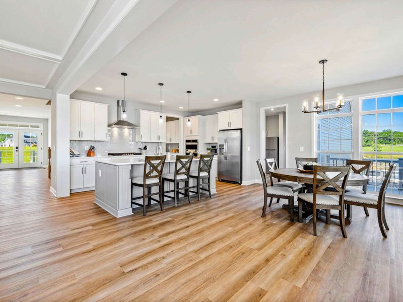 Expansive open kitchen and dining area with modern appliances and ample natural light