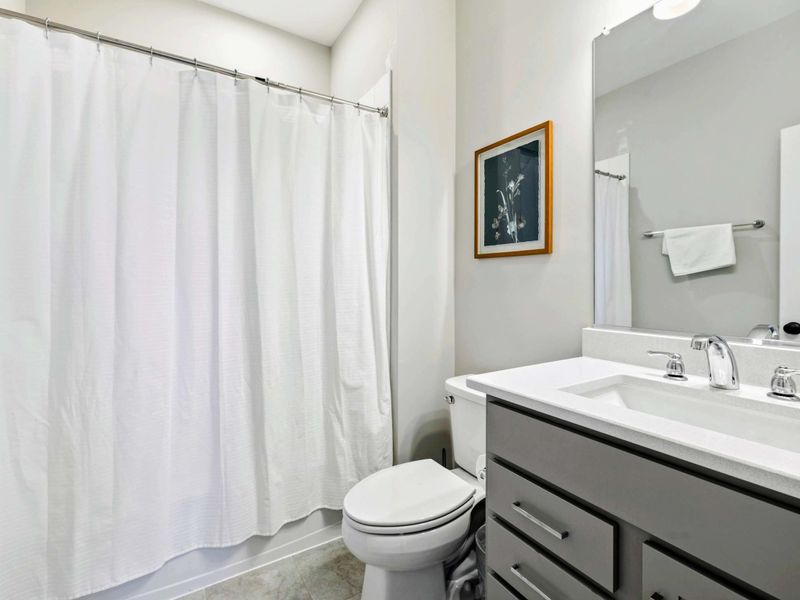 Modern bathroom with a shower-tub combination and sleek vanity