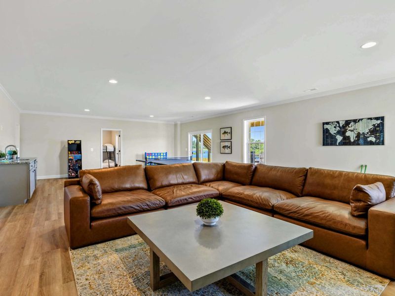 Spacious entertainment room with comfortable seating, games, and a view of the lake.
