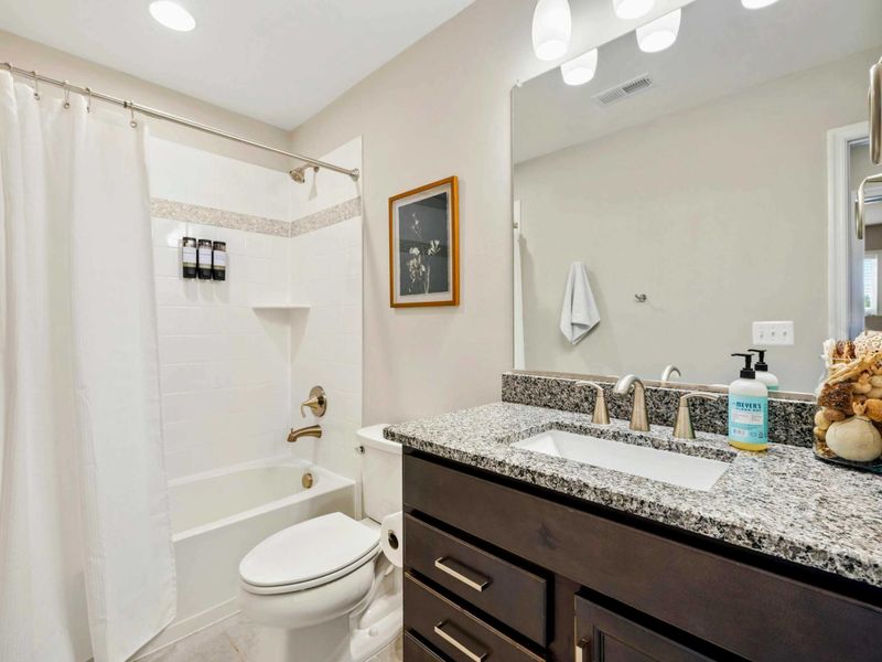 Chic bathroom with a shower-tub combo and granite vanity