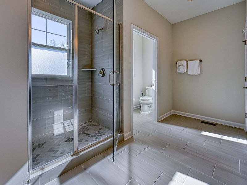 Spa-Inspired Simplicity – Clean lines, glass, and stone create a shower that feels polished and quietly luxurious.