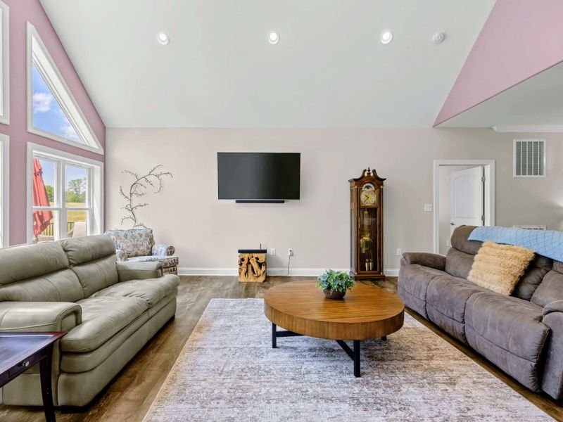 Living Room - Gray leather couches and a tufted accent chair angle toward the TV for relaxed evenings in.