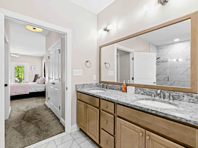 Primary Bathroom - Granite double vanity opens directly to the primary suite for an easy morning routine.