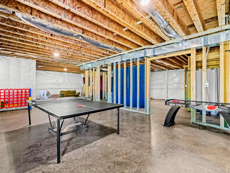 Game Room - Wide view of the lower-level rec area with ping pong and air hockey set up side by side.