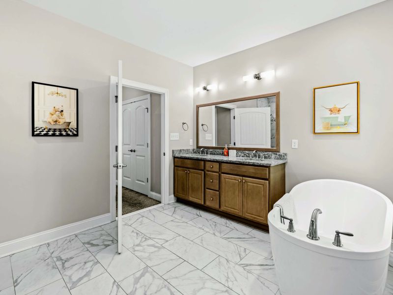 Primary Bathroom - Wide view linking the double vanity, soaking tub, and separate water closet.
