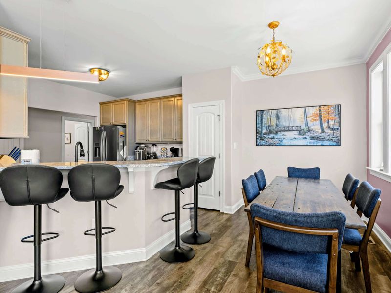 Dining Area - Blue velvet seating, gold chandelier light, and wall-to-wall windows make every meal feel relaxed.