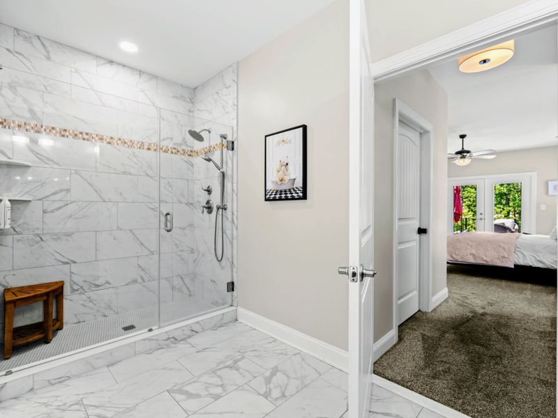 Primary Bathroom - Walk-in shower opens to a clear sightline back into the primary suite.