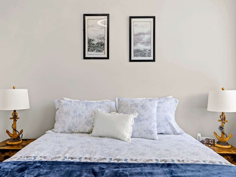 Bedroom 3 - Bed detail with two paired prints and a nautical anchor lamp on each nightstand.
