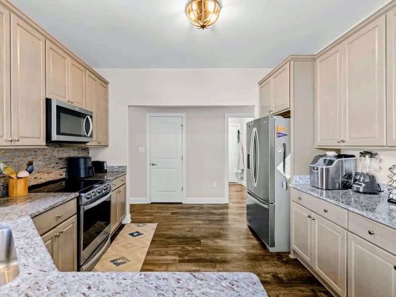 Kitchen - Stainless gas range, French-door fridge, and stone-tile backsplash bring the space up to date.