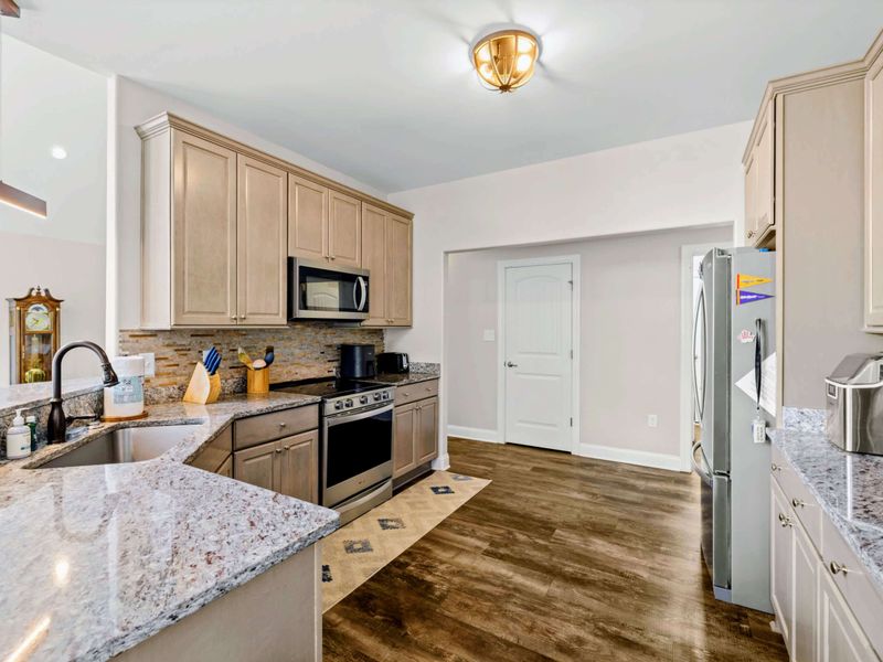 Kitchen - Cream cabinetry, granite counters, and stainless appliances keep the chef well equipped.