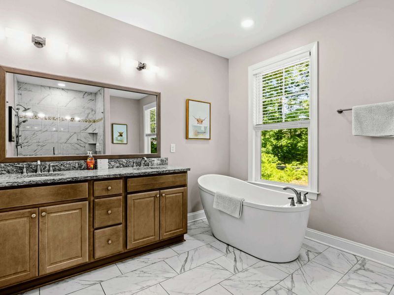 Primary Bathroom - Granite vanity and soaking tub by the window for an easy soak after a long day on the lake.