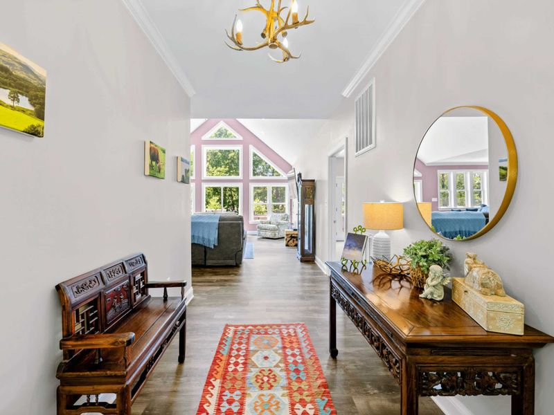 Entry Foyer - Welcoming foyer with antler chandelier, antique bench, and a kilim rug set the warm tone of the home.