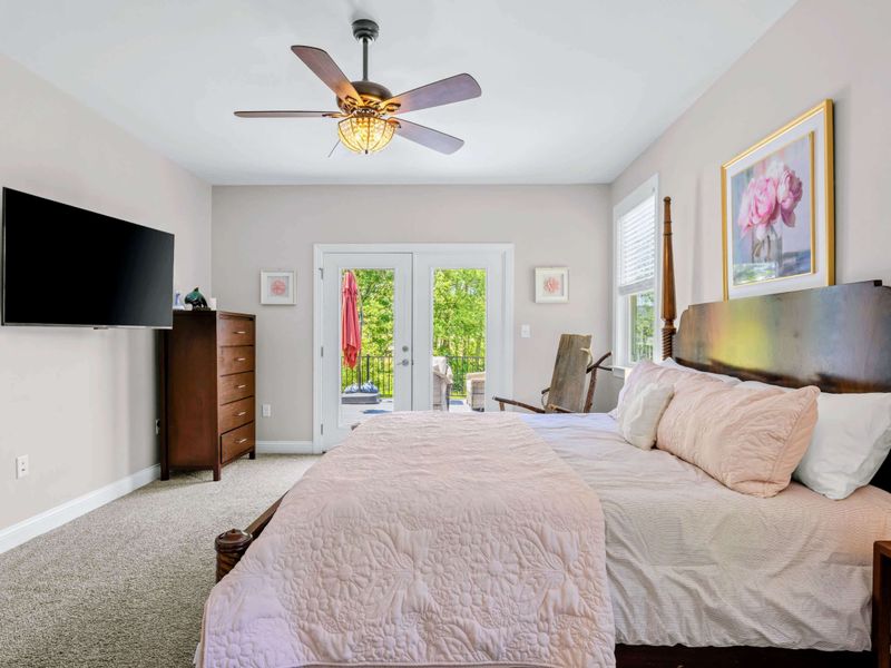 Primary Suite - Wall-mounted TV opposite the bed with a clear sightline to the doors out to the deck.