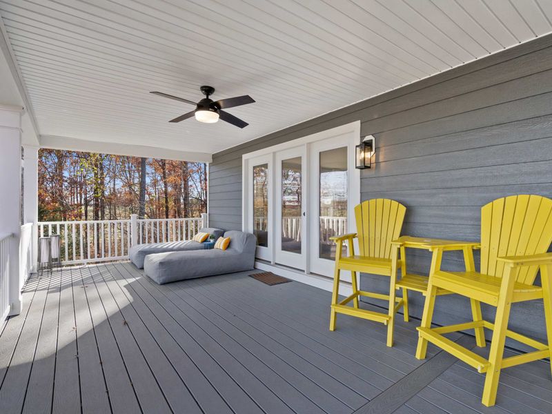 Upper Deck Entry - Yellow Adirondack bar chairs and a daybed lounger flank the French door entry to the main level.