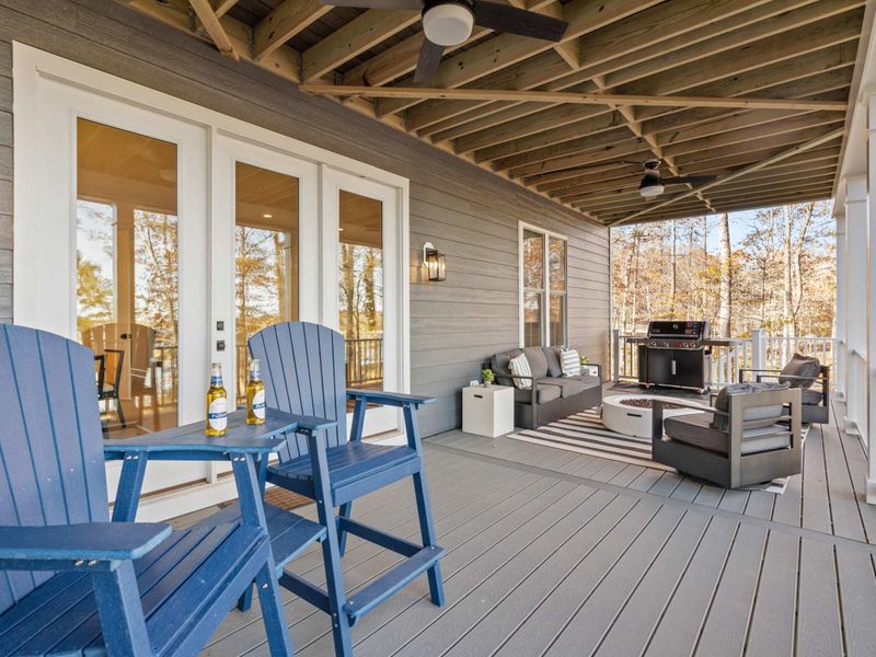 Lower Patio - Blue Adirondack bar chairs and a couch with a fire pit and grill make the lower deck perfect for evening cookouts.
