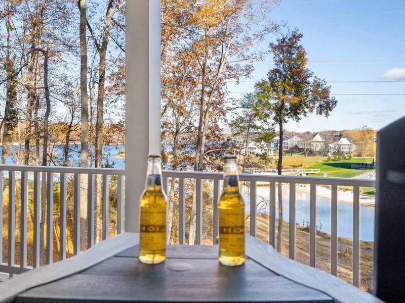Cheers to the Lake - Two cold ones on the railing with the water and neighborhood homes in the background.