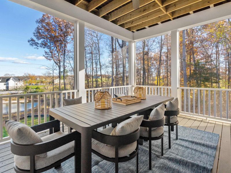 Outdoor Dining - A table for six on the lower covered deck, set with lanterns and surrounded by lake and tree views.