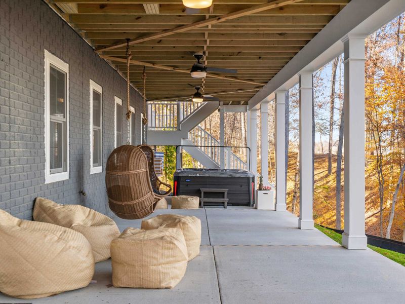 Swing and Soak - Hanging swing chairs and bean bags near the hot tub on the ground-level patio.