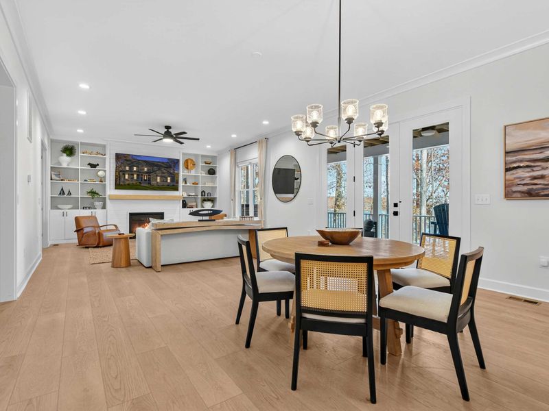 Dining Area - A round table for six with cane-back chairs sits between the great room and kitchen, under a glass chandelier.