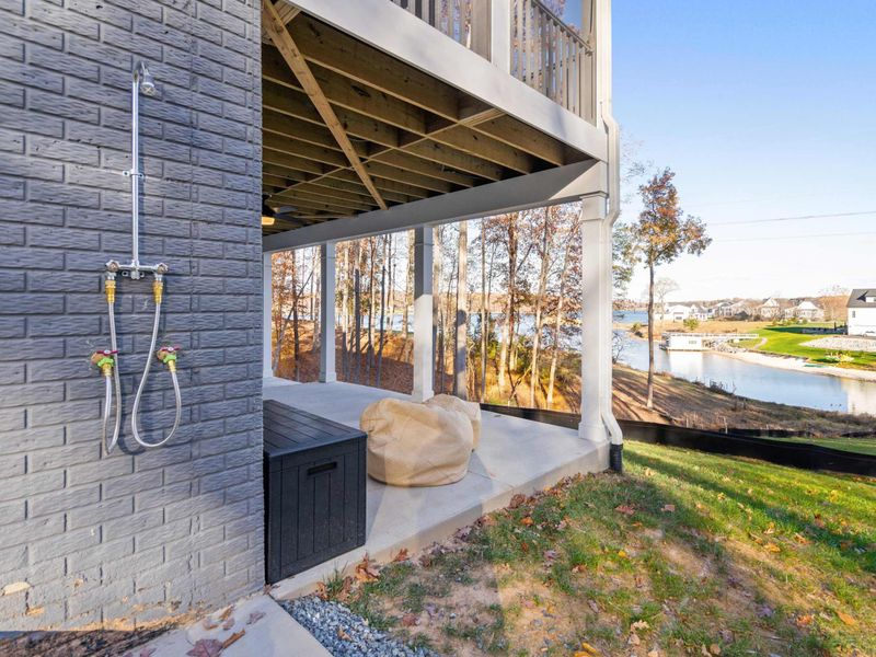 Outdoor Shower - Rinse off after a swim at the ground-level outdoor shower, with lake views and a storage bench nearby.
