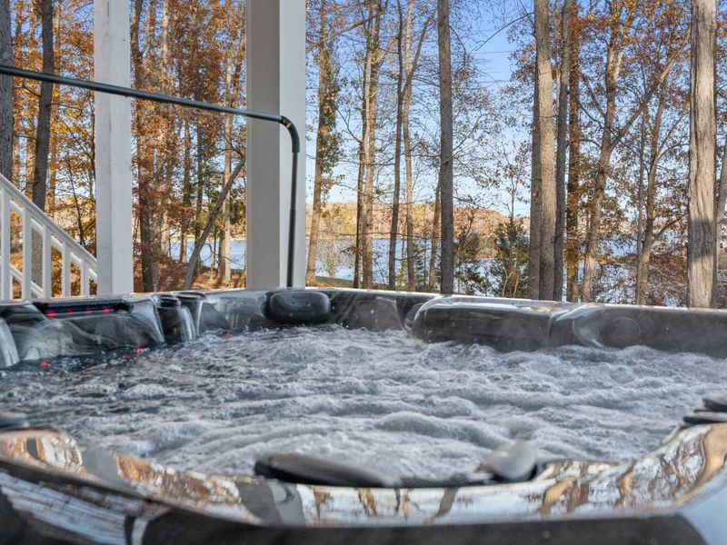Hot Tub Close-Up - Bubbling jets and lake views from inside the hot tub, framed by autumn trees and blue sky.