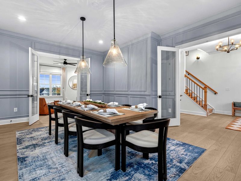 Dining to Staircase - The formal dining room connects to the great room through French doors, with the staircase to the upper level visible.