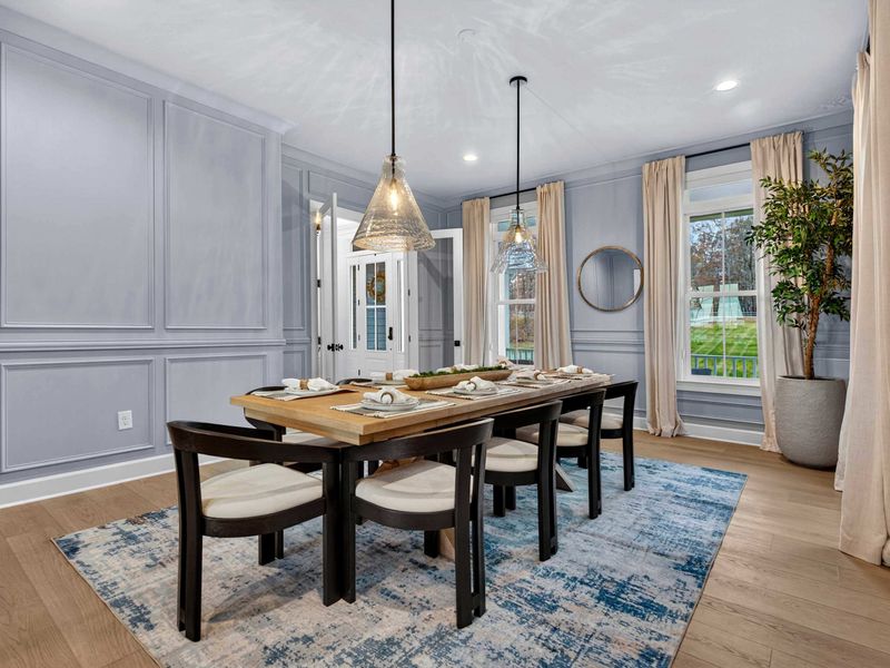 Dining Room - The full dining room with seating for eight, pendant lighting, wainscot paneling, and linen drapery.