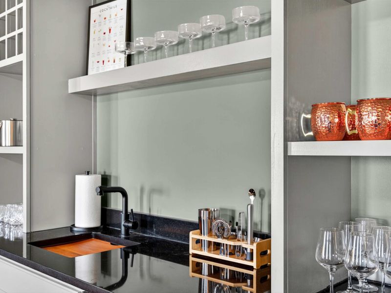 Bar Detail - A closer look at the wet bar with its sink, bar tools, copper Moscow mule mugs, and a curated cocktail station.