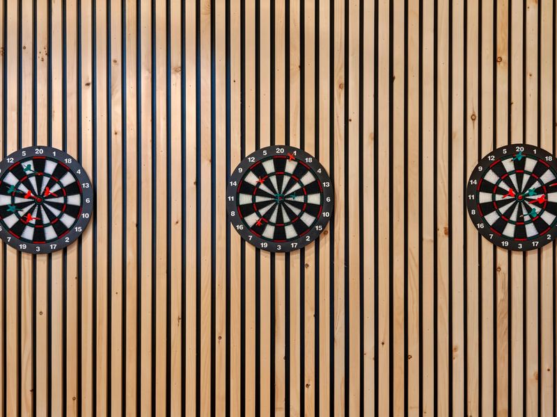 Dartboard Wall - The three dartboards on the slatted wood feature wall, viewed from the game bar.